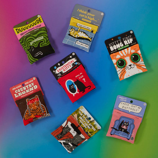 Seven colorful catnip toys in playful packaging with various cat-themed designs and funny phrases, arranged on a vibrant, gradient background.