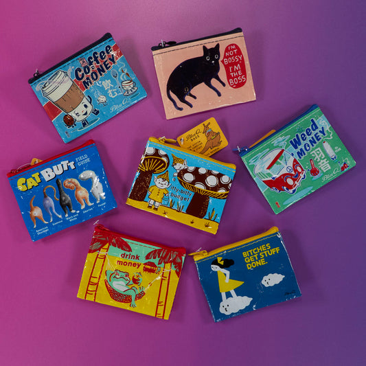 Seven colorful coin purses with playful illustrations and humorous text are arranged on a pink and purple gradient background. Each purse features a different design and caption.