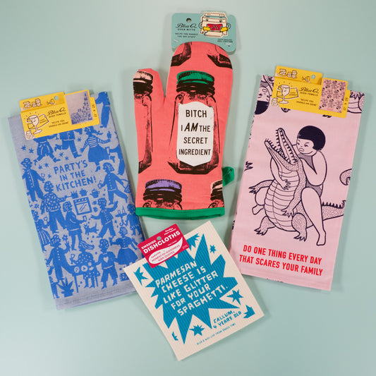Four colorful dish towels with quirky designs and sayings, including: “Party’s in the kitchen!”, “Bitch I am the secret ingredient!”, and “Do one thing every day that scares your family.”.