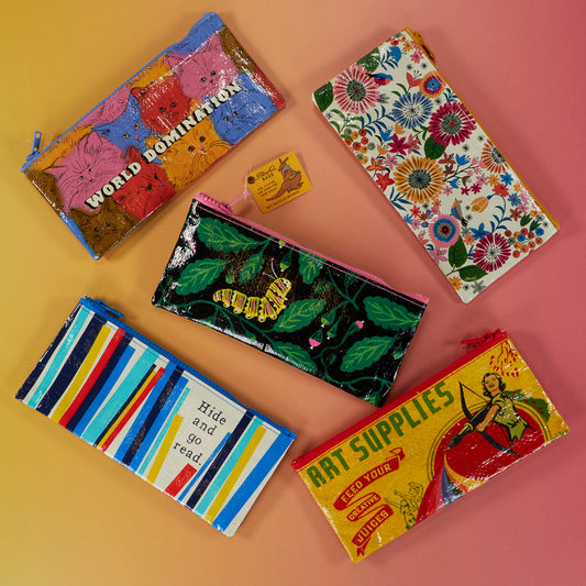 Five colorful zippered pouches with various designs, including cats, flowers, stripes, a caterpillar, and vintage-inspired art, displayed in a circle on a gradient pink and yellow background.