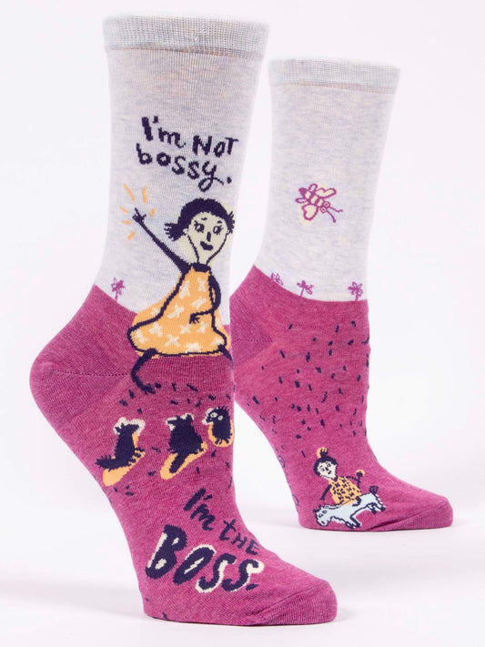 Blue Q's "I'm Not Bossy. I'm The Boss" W-Crew Socks feature fun designs: one sock shows a woman in an orange dress with “I'm Not bossy”; the other has a woman on horseback with “I'm the BOSS." Bold, statement socks for women.
