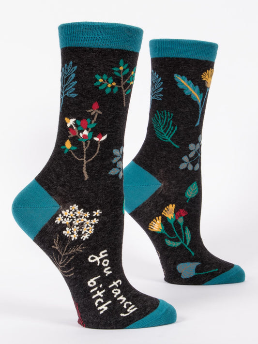 Blue Q You Fancy Bitch W-Crew Socks for women feature black combed cotton with blue cuffs, heels, and toes, colorful floral designs, and "you fancy bitch" in white on the side for extra comfort and style.