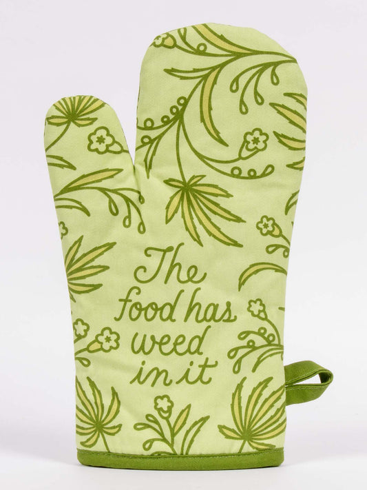 The Food Has Weed In It Oven Mitt by Blue Q features a green leafy design and the phrase “The food has weed in it” in cursive on the front.