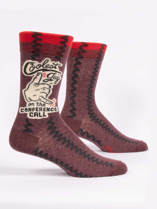 Blue Q's Coolest Guy On The Conference Call M-Crew Socks feature maroon zigzag patterns, red cuffs, and a hand with a coffee mug. Made from soft combed cotton, they make a fun workplace gift and display the phrase "Coolest guy on the conference call.
