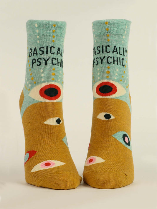 Blue Q Basically Psychic W-Ankle Socks feature a blue-green top, tan foot, colorful eye designs, and “BASICALLY PSYCHIC” in black on the upper part. Made from soft combed cotton.