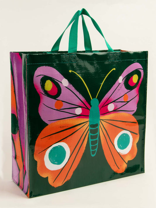The Blue Q Big Butterfly Shopper is a spacious 6.2-gallon reusable bag with green handles, featuring a vibrant butterfly graphic on a dark green background—perfect for stylish shopping or carrying your essentials.