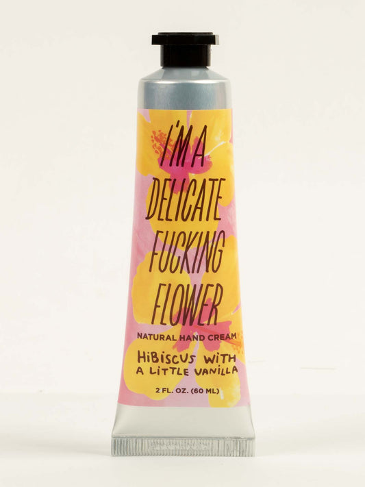 A 2 FL. OZ. tube of Blue Q's "I'm a Delicate Fucking Flower" Natural Hand Cream—hibiscus with a little vanilla, enriched with shea butter and almond oil. Colorful label included.