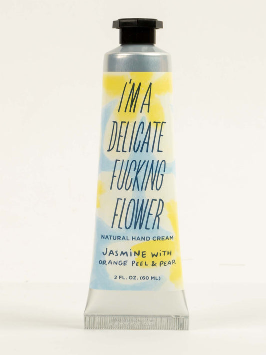 Blue Q I'm a Delicate Fucking Flower Natural Hand Cream—jasmine, orange peel, and pear with almond oil for softness. 2 fl. oz. (60 mL) tube with a colorful label.