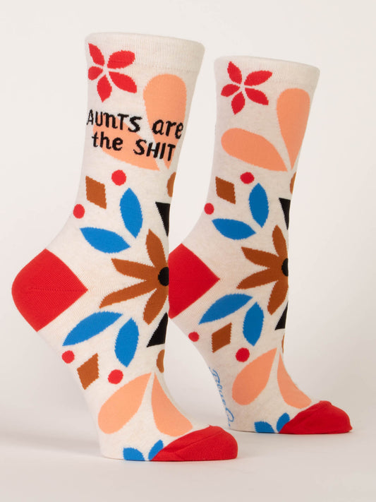 Blue Q Aunts Are The Shit W-Crew Socks: white crew socks with red toes and heels, made from soft combed cotton, featuring blue, red, peach, and brown floral patterns and “AUNTS are the SHIT” in bold black and orange text.