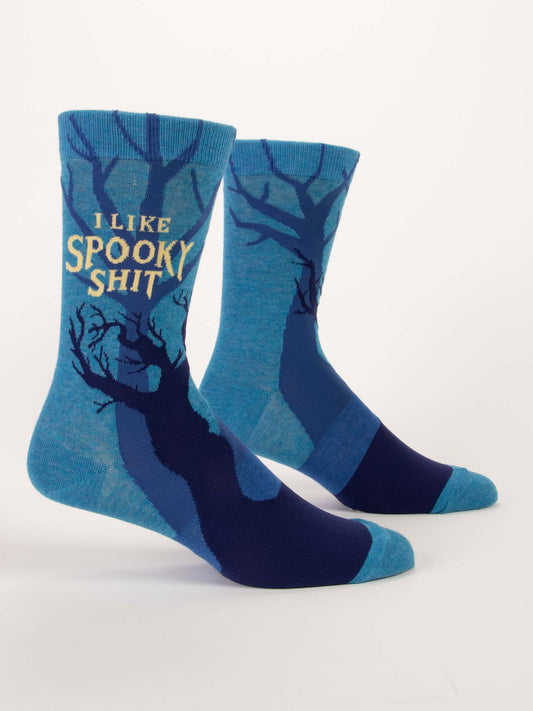 Blue Q's I Like Spooky Shit M-Crew Socks are blue combed cotton socks with a dark tree silhouette and “I LIKE SPOOKY SHIT” in yellow on the side—perfect for Halloween.