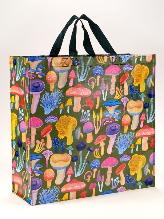 The Mushrooms Shopper by Blue Q is a reusable grocery bag with black handles, featuring a vibrant illustration of various mushrooms and fungi specimens on a green background.