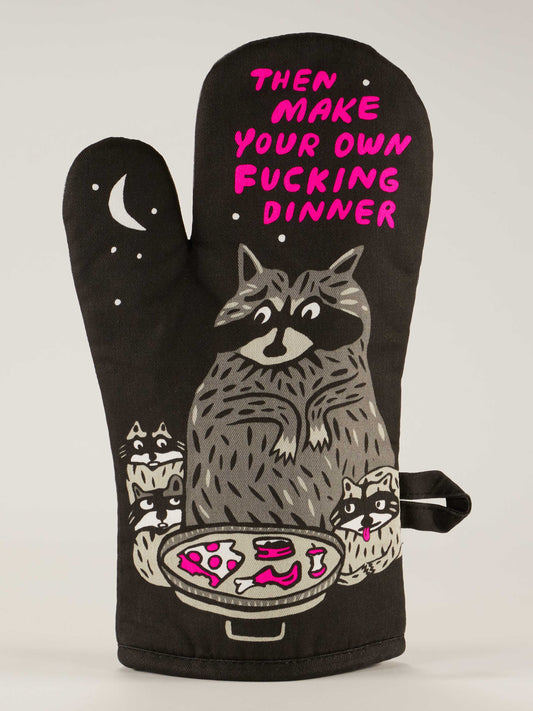 The Blue Q "Then Make Your Own Fucking Dinner" Oven Mitt features a cartoon raccoon family eyeing food, bold pink text, and playful details like a crescent moon, stars, and trash on a black background.