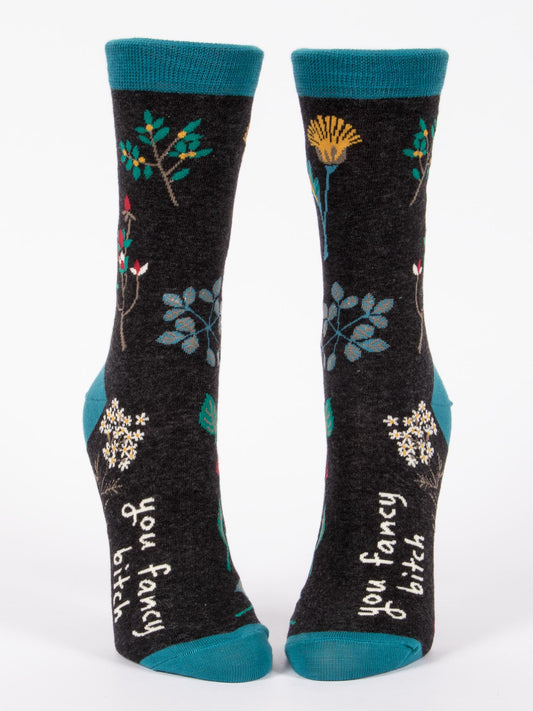 Blue Q’s You Fancy Bitch W-Crew Socks are black women’s socks with teal cuffs, heels, and toes, floral designs, and “you fancy bitch” in white by the ankles. Made from soft combed cotton for extra comfort.