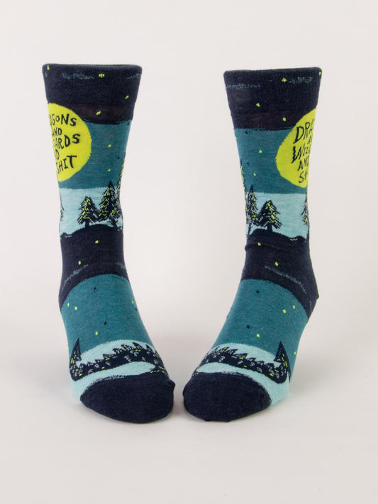 Blue Q Dragons And Wizards And Shit M-Crew Socks: blue combed cotton socks with trees, a dragon, and a yellow moon night scene, plus the phrase "Dragons and wizards and shit" on them.