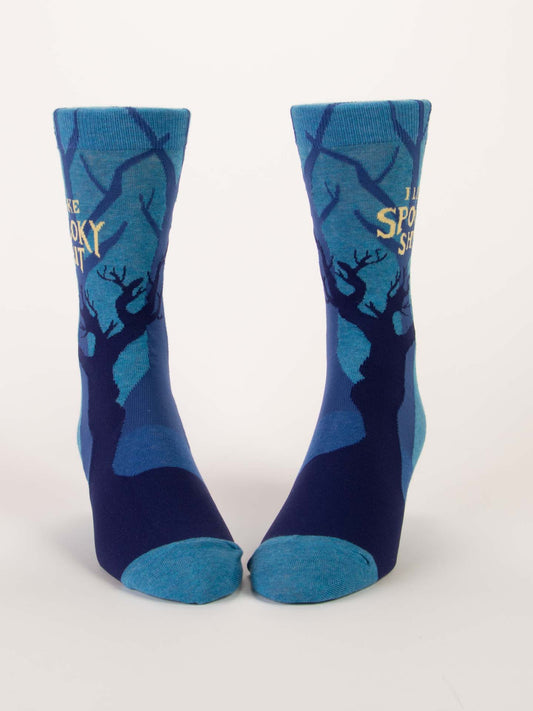 Two blue Blue Q "I Like Spooky Shit" M-Crew Socks with dark blue and black tree silhouettes, "IM SPOOKY AS SHIT" near the top, made of soft combed cotton, shown on a white background.
