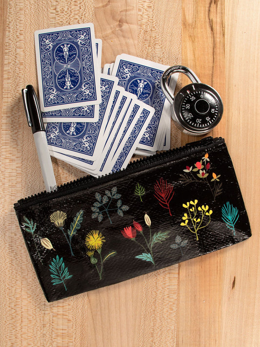 A Blue Q Plant Study Pencil Case, a black marker, a combination padlock, and scattered playing cards lie on a wooden surface.