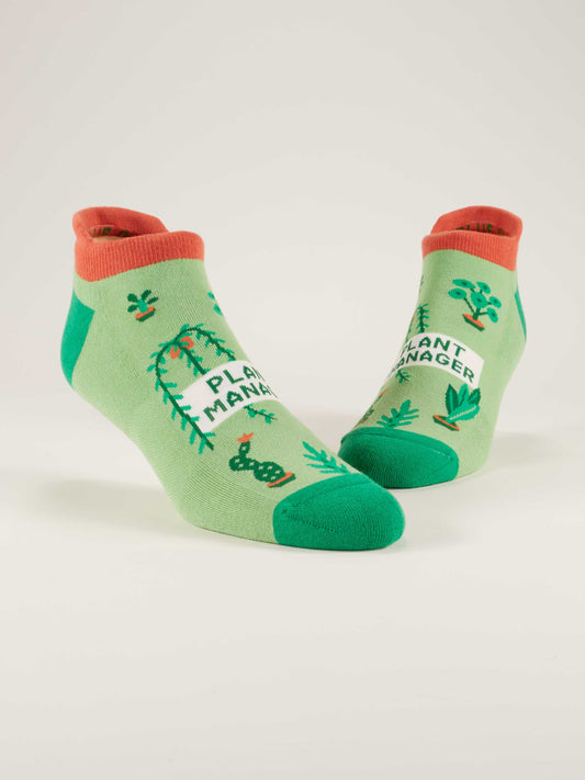 Blue Q Plant Manager Sneaker Socks are soft heel tab ankle socks with orange accents, potted plant illustrations, and “Plant Manager” on the front for comfort and style.