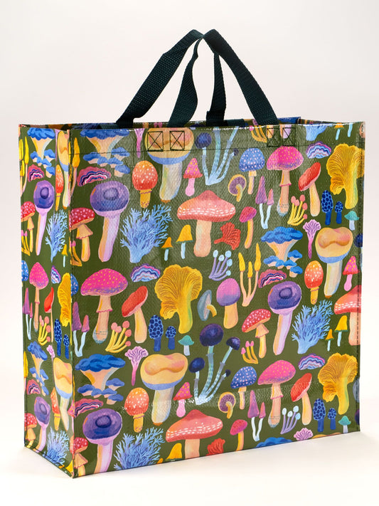The Blue Q Mushrooms Shopper is a reusable grocery bag with black handles, featuring a vibrant pattern of illustrated fungi and mushrooms on a green background.