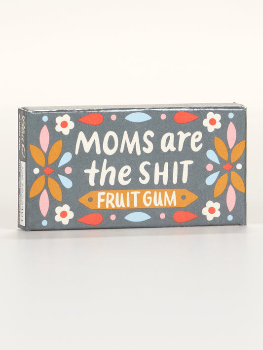 A rectangular box of Blue Q's Moms Are The Shit Gum, featuring a floral design and the product name boldly displayed in white and orange on the front.
