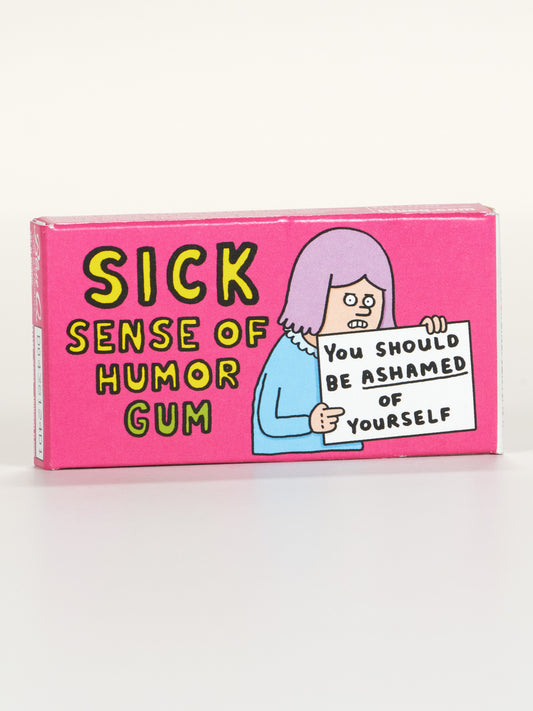 Blue Q’s Sick Sense Of Humor Gum comes in a pink box featuring a cartoon with purple hair holding a "You should be ashamed of yourself" sign. Each box includes 8 pieces of mint-flavored gum.