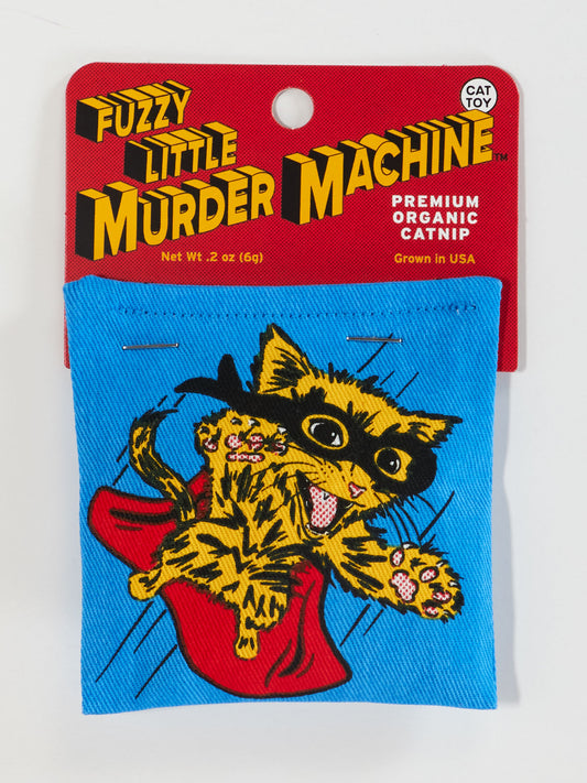 The Fuzzy Little Murder Machine Catnip Toy by Blue Q features a wild-eyed, orange-striped cat on a blue plush, packed under a red label and filled with premium organic USA-grown catnip for healthy feline fun.