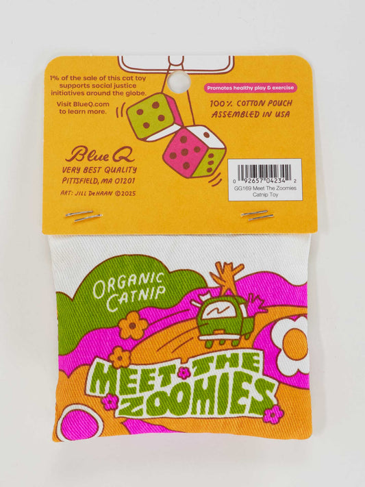 The Blue Q Meet The Zoomies Catnip Toy is a 100% cotton pouch with organic catnip, featuring a cartoon cat on an orange and white floral background. This colorful toy also supports social justice initiatives.
