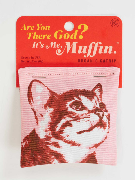 Blue Q's "Are You There God? It's Me. Muffin." Catnip Toy features a pink package with a red cat face, "Organic Catnip" text, and a cotton pouch design, perfect for healthy, fun play for cats who love organic catnip.