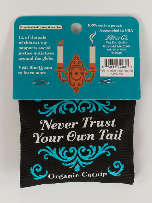 The Blue Q Never Trust Your Own Tail Catnip Toy features organic catnip, a blue pouch with white and orange artwork, promotes healthy play, donates to social causes, and showcases "Never Trust Your Own Tail" in bold text.