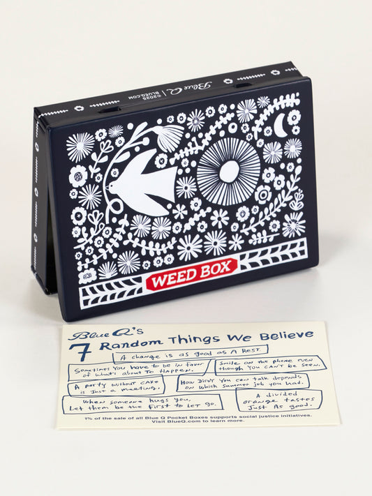 The Blue Q Weed Box Pocket Box, a decorative black storage container with white floral and bird designs labeled "WEED BOX," is displayed behind a handwritten note titled "7 Random Things We Believe.