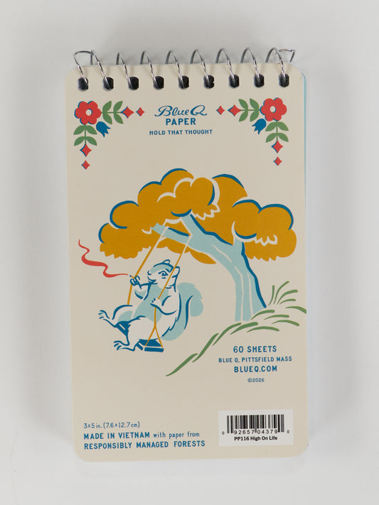 The Blue Q “High On Life...And Possibly Weed” 3x5 spiral notebook features 60 sheets, a fun squirrel-on-a-swing design with red and blue flowers, and is made in Vietnam from responsibly managed forests. Perfect for jotting down ideas.