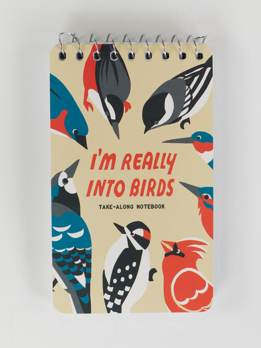 The Blue Q I'm Really Into Birds. Take-Along Notebook is a 3x5 spiral notebook with vibrant bird illustrations and bold red "IM REALLY INTO BIRDS" lettering, ideal for notes, sketches, or observations.