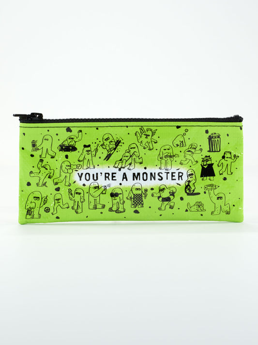 The Blue Q "You're A Monster Pencil Case" is a green zippered pouch with black cartoon monster drawings and bold white "YOU'RE A MONSTER" text—perfect for organizing your supplies.