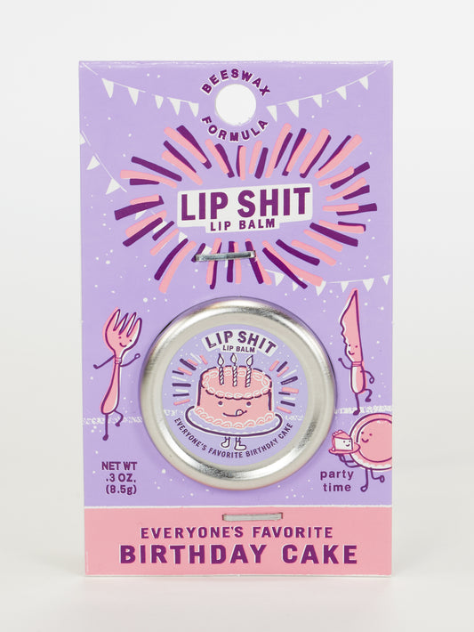 A .3 oz package of Blue Q Lip Shit Lip Balm-Everyone's Favorite Birthday Cake, in purple packaging with a cartoon cake and festive decorations.