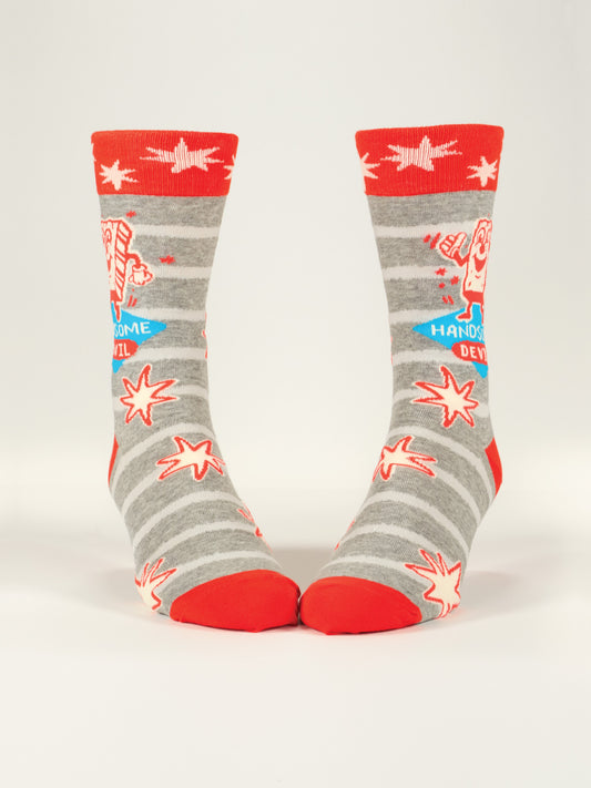 The Handsome Devil M-Crew Socks by Blue Q are gray combed cotton socks with white stripes, red accents, cartoon devil characters, red stars, and "Handsome Devil" text in blue and red on the sides.