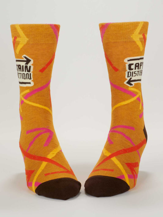 The Blue Q Captain Distraction M-Crew Socks are orange combed cotton with brown toes, pink and yellow squiggly lines, and a "CAPTAIN DISTRACTION" patch near the top.