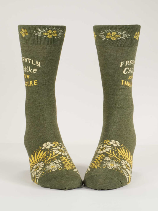 Blue Q’s Frequently Childlike Often Immature M-Crew Socks feature green combed cotton, yellow and white floral accents, and playful text—ideal for those with a repertoire of unwelcome nicknames.