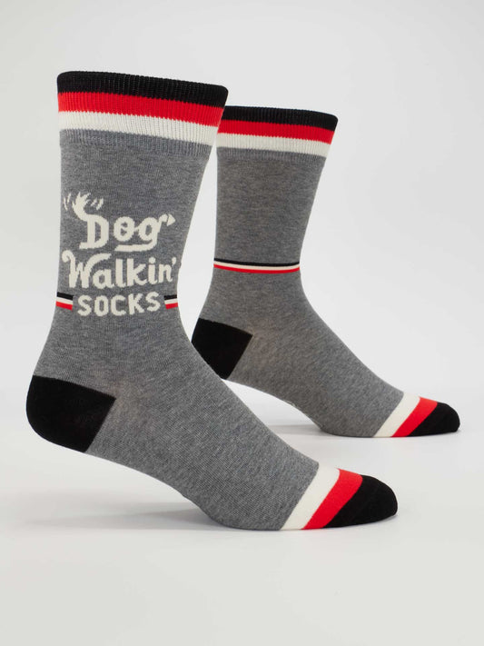 Blue Q Dog Walkin' Men's Socks—gray cotton socks with black, white, and red striped cuffs, heels, and toes. One sock features a white dog's face graphic and reads "Dog Walkin' Socks." Fun and playful for men.