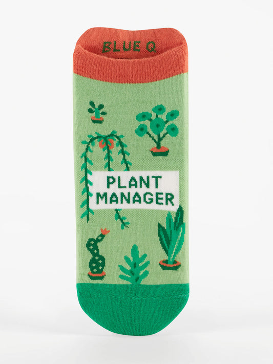 The Plant Manager Sneaker Socks by Blue Q are green with red trim, decorated with potted plant illustrations and "PLANT MANAGER" in bold letters. Featuring a soft heel tab, these socks combine extra comfort with playful style.