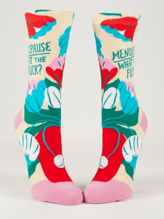 Blue Q Menopause. What The Fuck? W-Crew Socks feature soft combed cotton and spandex, colorful abstract patterns in red, pink, turquoise, and green, bold solid pink heels/toes, and the phrase "MENOPAUSE WHAT THE FUCK?" among flowers and shapes.
