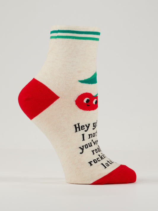 Blue Q’s Hey Girl Hey! I Noticed You’ve Been Really Rocking It Lately. W-Ankle Socks feature a cream base with green stripes, red heel and toe, and a cute tomato graphic plus playful text: “Hey girl, I notice you’ve really been rocking that latte.”.