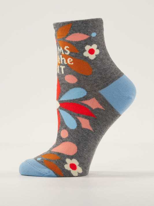 Blue Q’s "Moms Are The Shit" W-Ankle Socks feature soft gray combed cotton, blue heel and toe, and a colorful floral pattern in red, orange, blue, and white with partially visible text for moms.