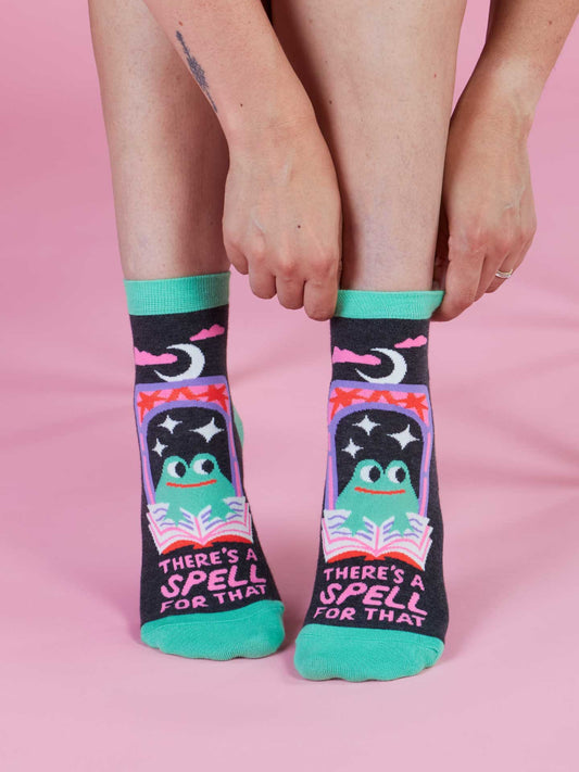 Blue Q’s “There’s A Spell For That” Ankle Socks feature a cartoon frog reading on a starry night, green toes and cuffs with a pink background. Fits women’s shoe size 5–10. Perfect for fans of cute, cozy style!.