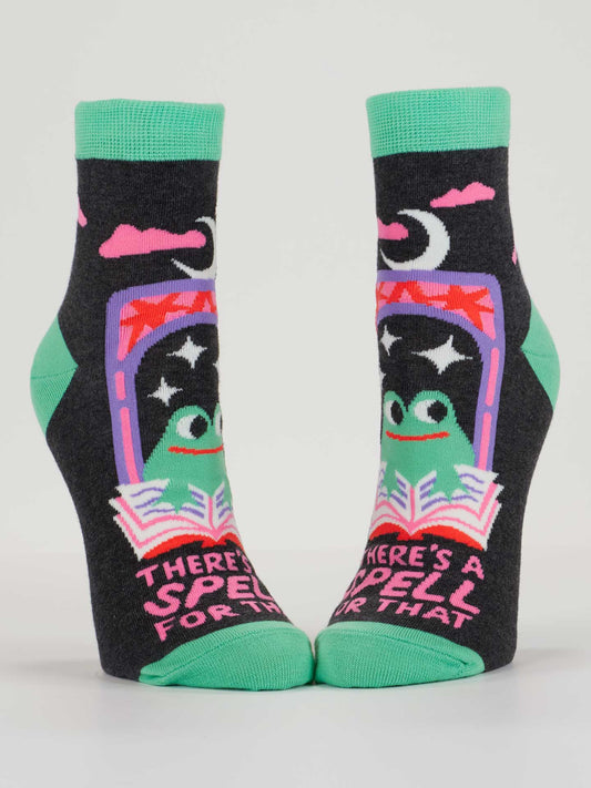 Blue Q’s There’s A Spell For That Ankle Socks, sized for women’s 5-10, feature green toes and cuffs, playful frogs, stars, a crescent moon, and "There’s a spell for that" in pink amid colorful patterns.