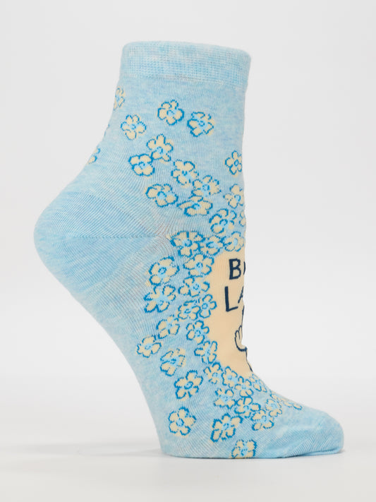 The Blue Q Bird Lady W-Ankle Socks are light blue ankle socks made from soft combed cotton with a playful blue and white flower pattern, cartoon hand detail, and black text—perfect for pairing with your favorite women’s shoes.