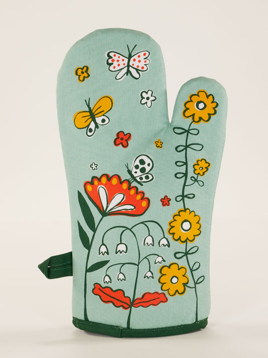 The Please, One Shitstorm At A Time Oven Mitt by Blue Q is a light green mitt featuring vibrant flowers and butterflies—ideal for adding style and humor to your breakfast or lunch prep.