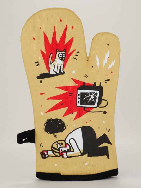 The "It's A Great Day To Yell At Football" oven mitt by Blue Q is yellow and displays cartoon-style chaos—a scared cat with red spikes, a shattered TV with sparks, and a person kneeling, crying under a scribble cloud.