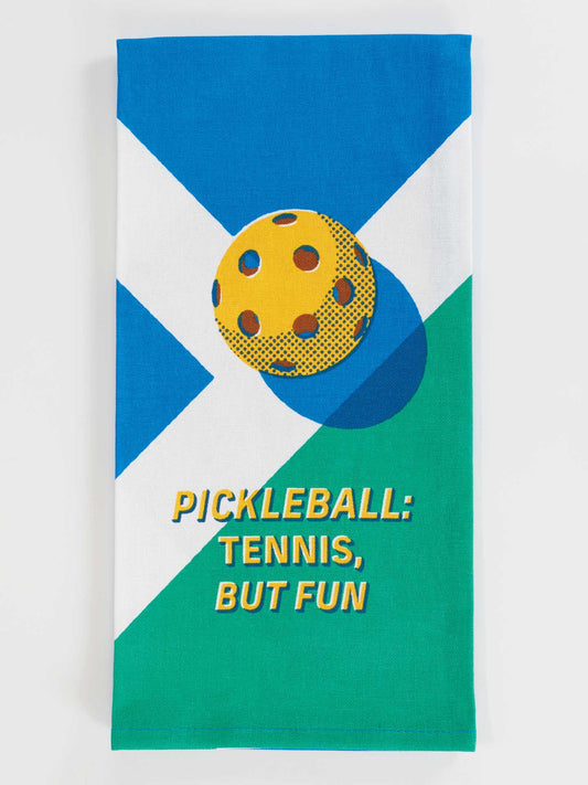 The Blue Q Pickleball: Tennis, But Fun Dish Towel features blue, green, and white sections, a yellow pickleball graphic, and bold yellow text—an ideal family-friendly towel for lively briney courts.