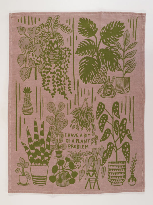 The Blue Q "I Have A Bit Of A Plant Problem" Dish Towel features green potted plant illustrations and the playful phrase on a light brown background—an ideal, charming accent for your home decor.