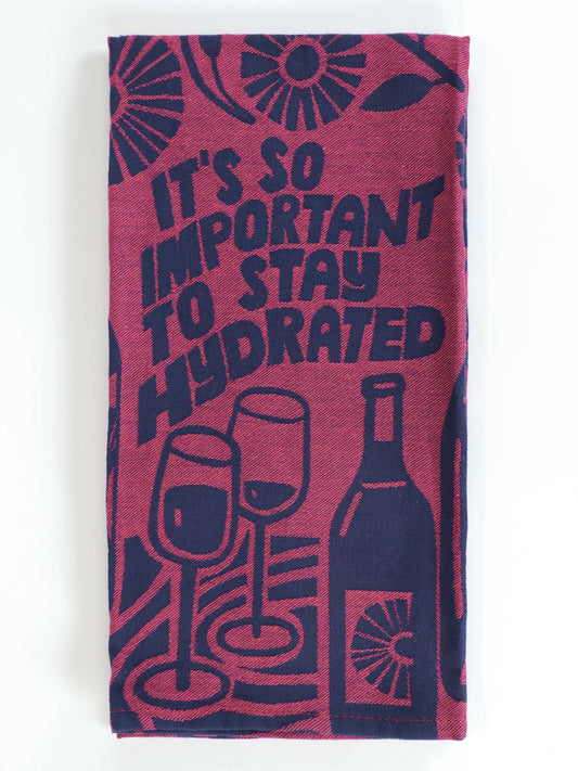 The Blue Q “It’s So Important To Stay Hydrated Dish Towel” features playful wine bottle and glass illustrations with its amusing hydration reminder in burgundy and navy.