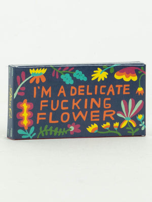 A rectangular box from Blue Q, featuring vibrant floral art and bold orange text—I'm A Delicate Fucking Flower Gum—makes a fun way to stash your favorite fruit-flavored gum.